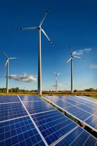 Wind turbines and solar panels closeup on sky background